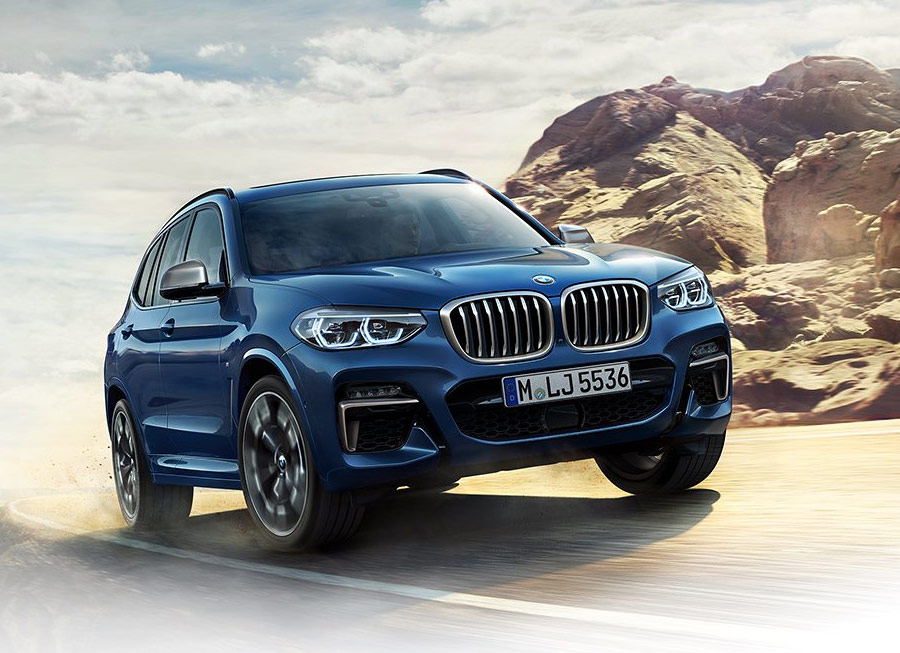 a blue BMW x3 suv in a highway