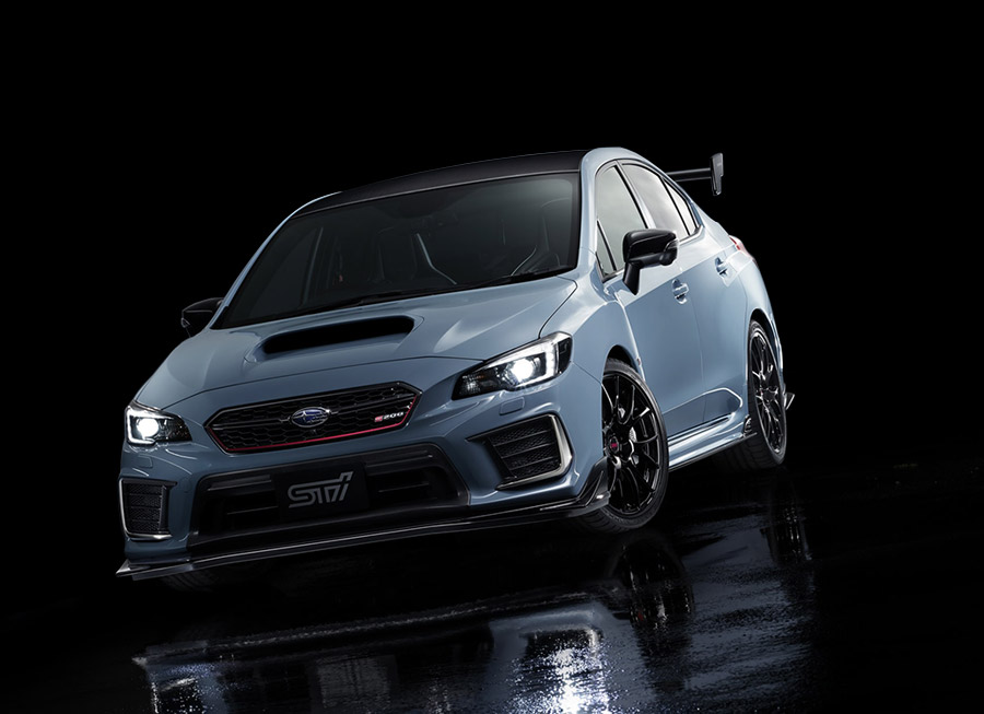 a white subaru impreza sedan inside a dark background